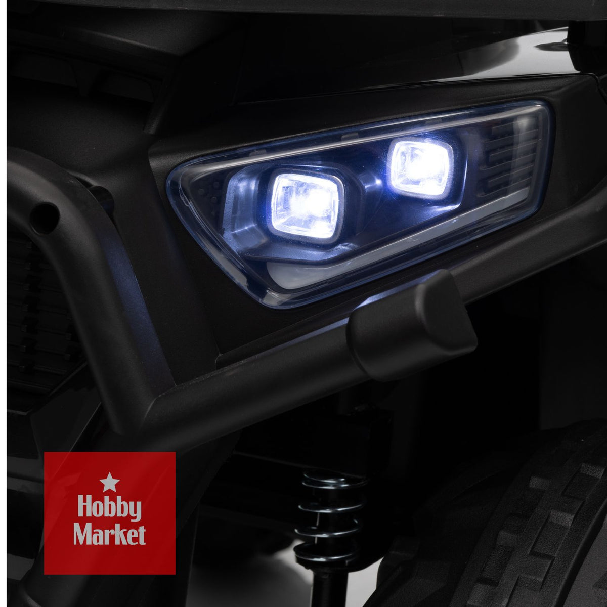 Detalle de luces LED brillantes y defensa frontal robusta en cuatrimoto eléctrica infantil negra.