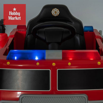 Camión de bomberos eléctrico infantil rojo con luces de emergencia, volante y asiento negro con emblema de bombero.