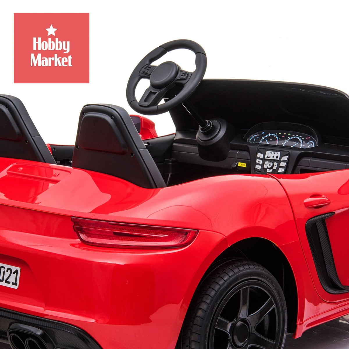 Interior de auto eléctrico infantil rojo de dos plazas con volante, tablero detallado y asientos deportivos negros.
