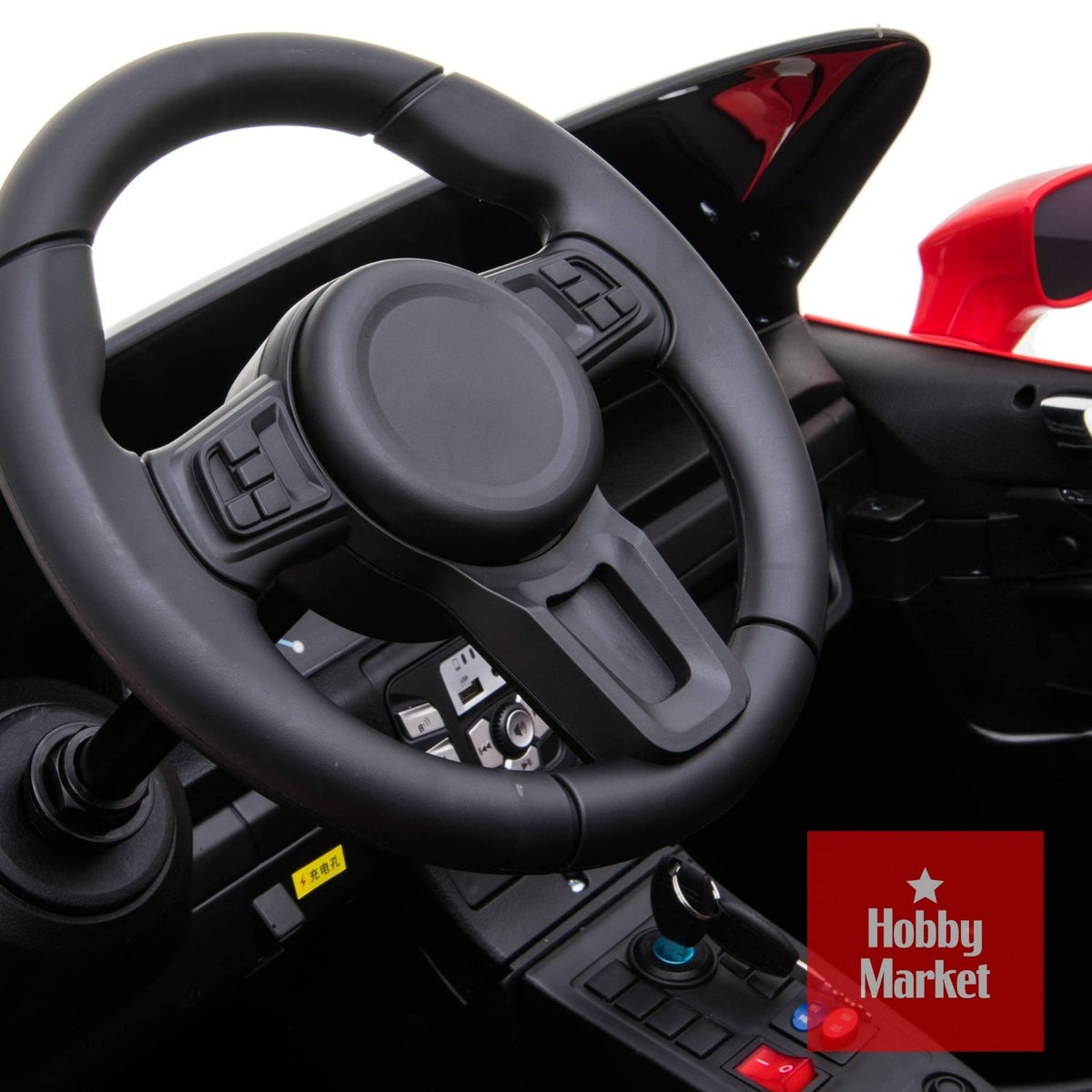 Volante negro y tablero detallado de auto eléctrico infantil rojo Pro 24V con controles y botones de mando.